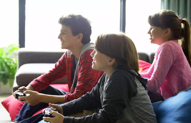 Трое детей играют в видеоигры Xbox